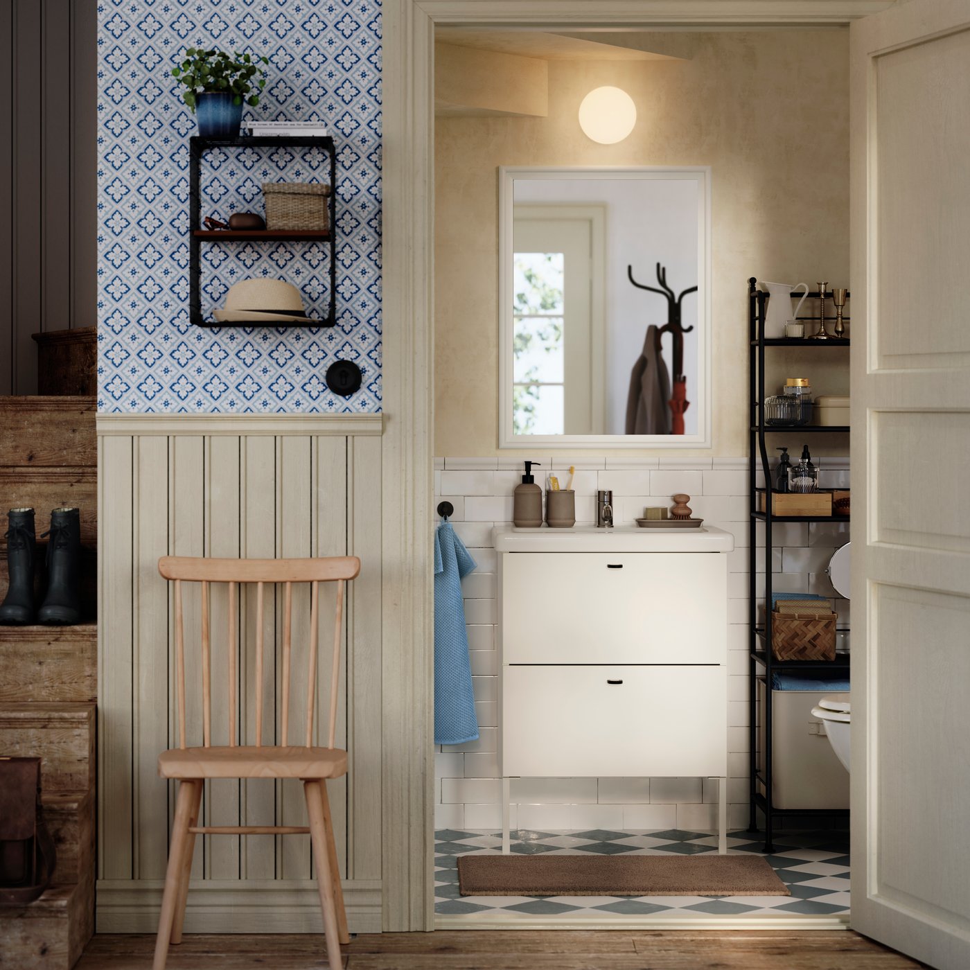 A white ENHET/TVÄLLEN wash-stand with drawers and legs is on a tiled wall in a traditional-styled half bath under stairs.