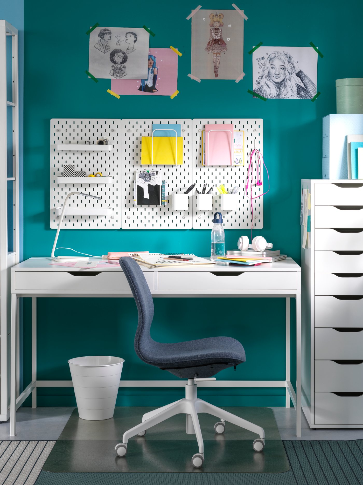 An IKEA ALEX white desk with drawers next to a matching drawer unit in an office with bright blue walls.