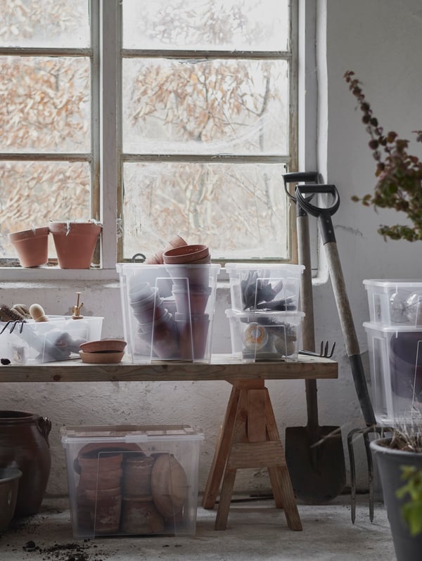 SAMLA transparent boxes standing on an old wodden bench with pots in the boxes