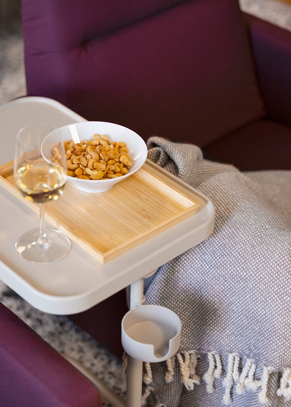 Una mesa con bandeja BJÖRKÅSEN frente a un sofá IKEA.