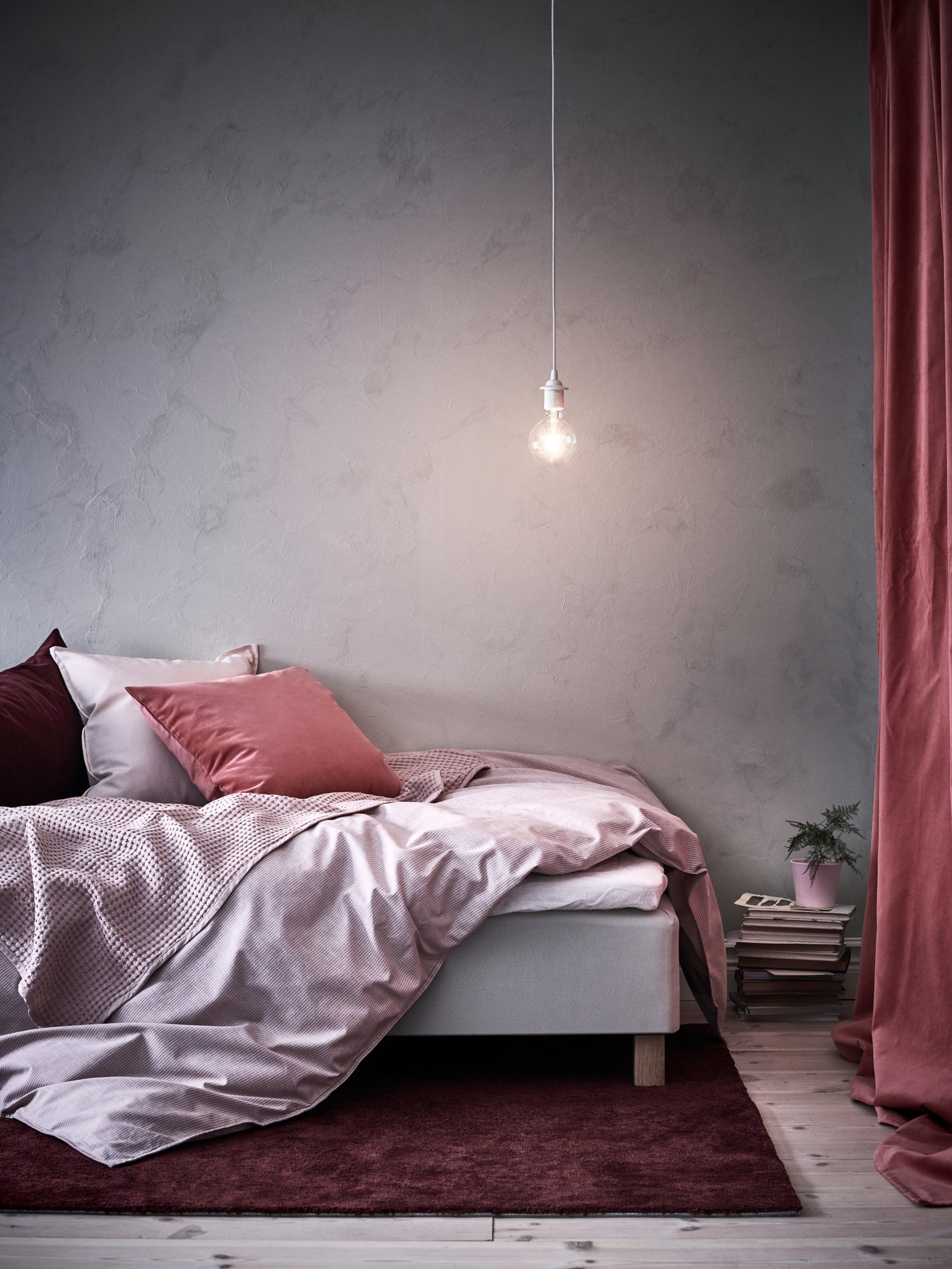 Ein Bett mit aufgeschlagener Bettdecke, die über den Bettrahmen hängt und mehreren Kissen