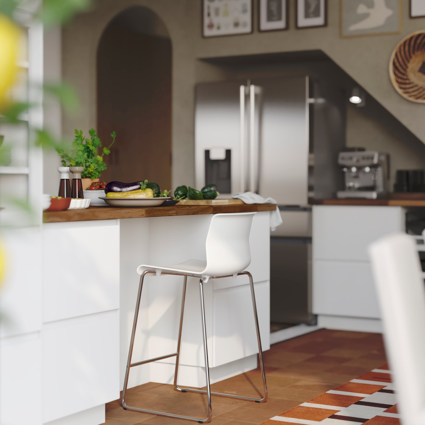 A GLENN bar stool is placed next to a kitchen peninsula with storage in drawers with matte white VOXTORP fronts.