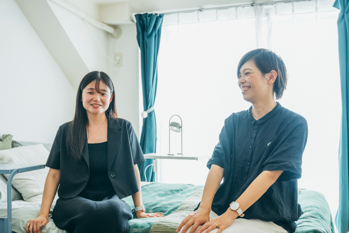 ベッドに腰を掛け談笑するイケアスタッフSahoと相談者