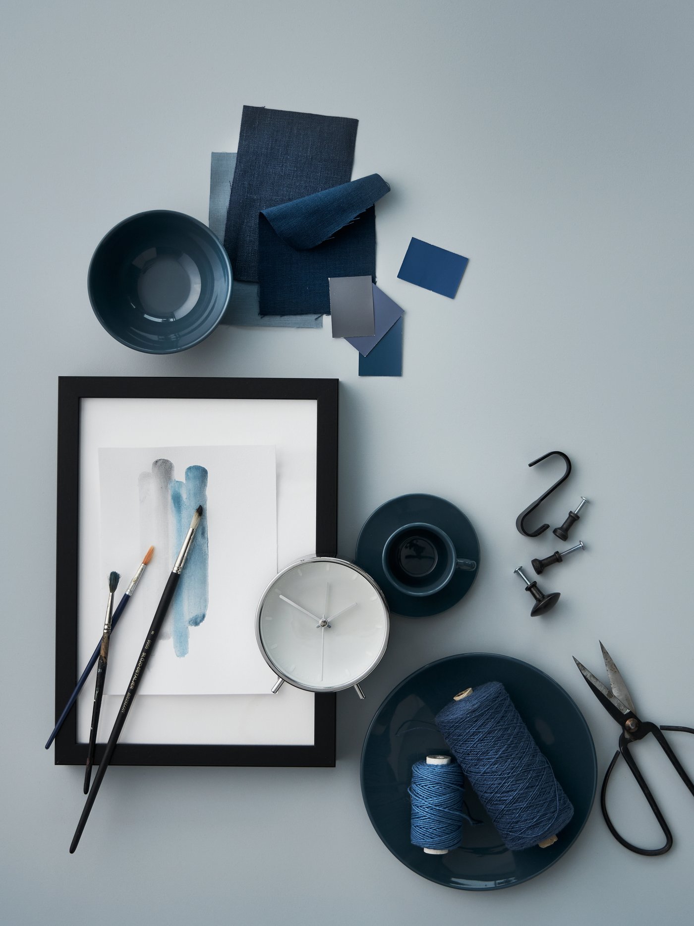 Des articles éparpillés aux teintes de bleu : de la vaisselle FÄRGKLAR turquoise foncé, un réveil MALLHOPPA, de la corde et du tissu.