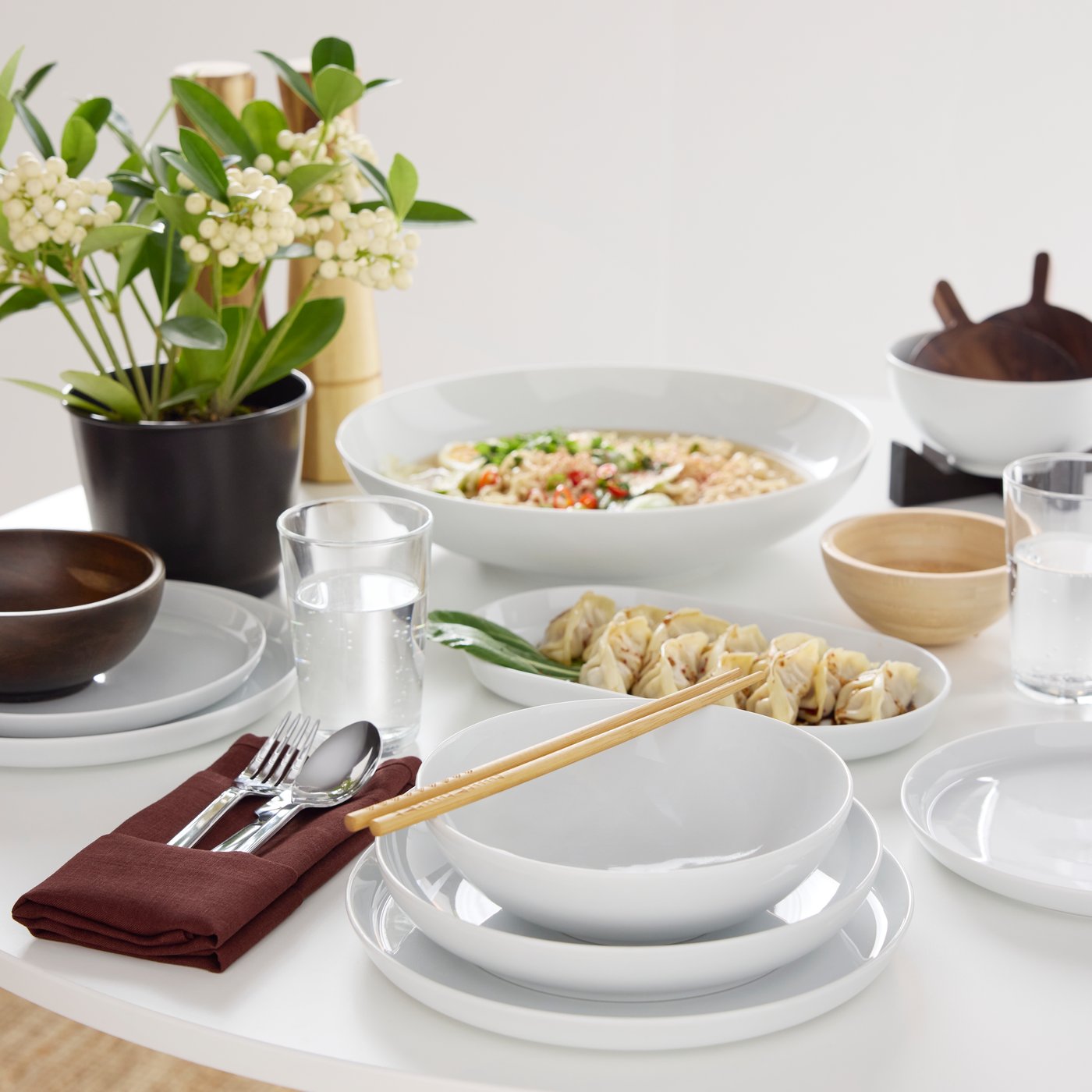 Ein für eine Mahlzeit gedeckter Tisch mit Speisen sowie einer IKEA 365+ Schüssel, einer IKEA 365+ Servierschüssel und einer BLANDA MATT Servierschüssel aus Bambus.