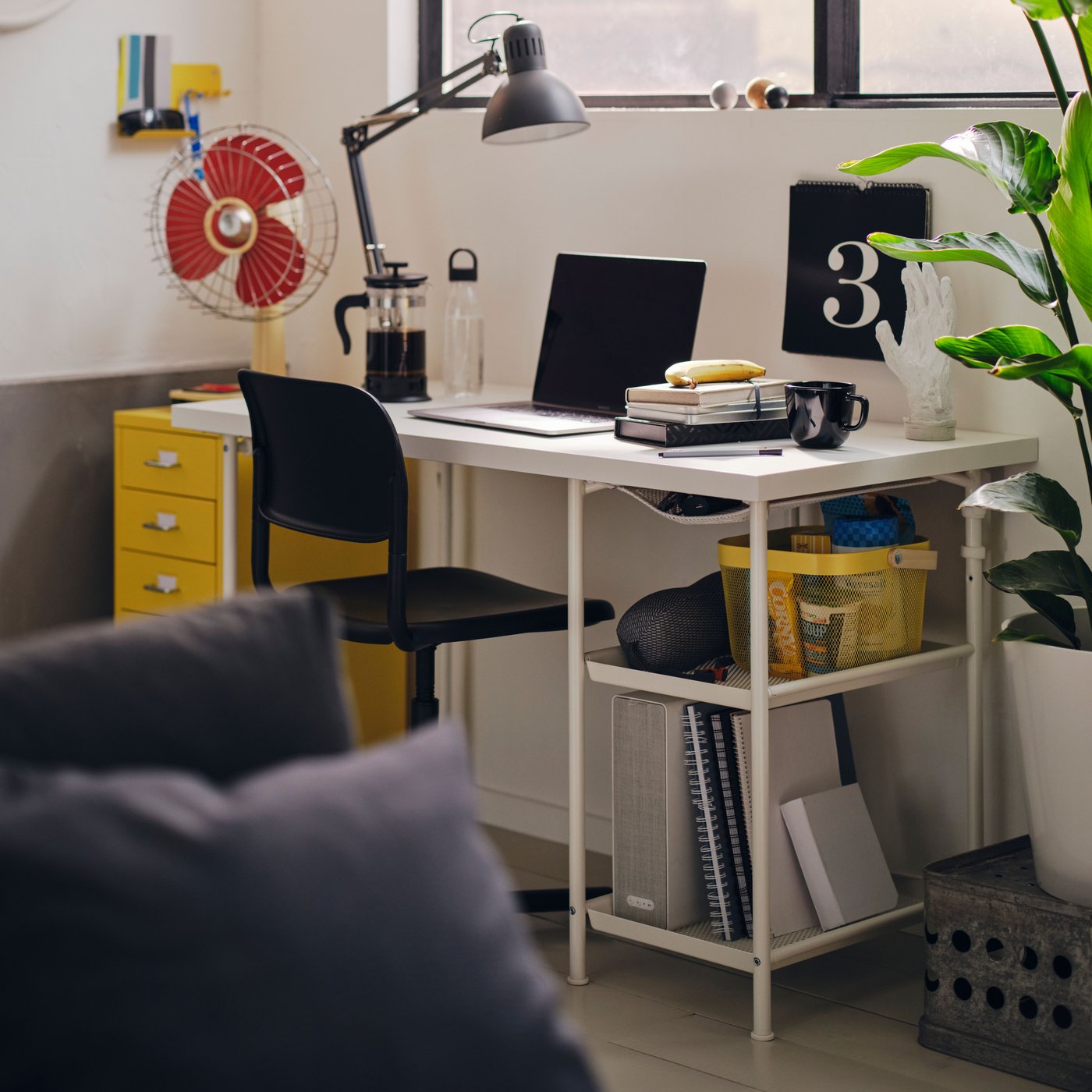 A customisable LAGKAPTEN desk with a black office chair and a black TERTIAL desk lamp in a home workspace.