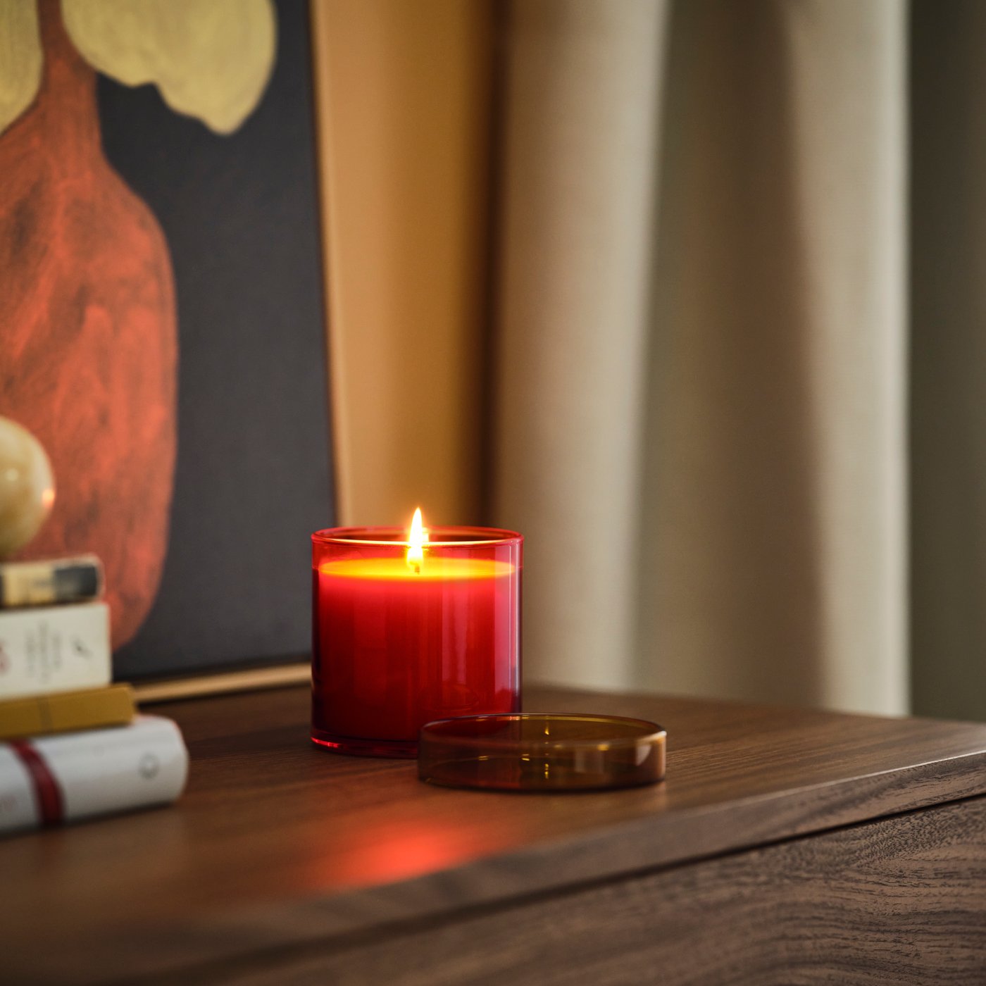 A Citrus flower red-orange/yellow-brown DVÄRGHÖK scented candle in glass with lid in the living room