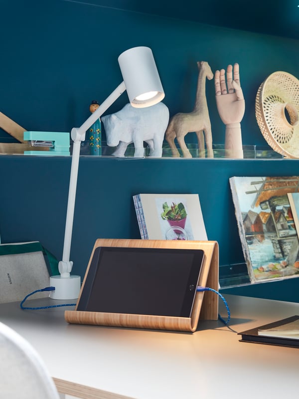NYMÅNE work lamp illuminates a tablet on a tablet stand and a cord from the lamp’s built-in USB port charges the tablet.