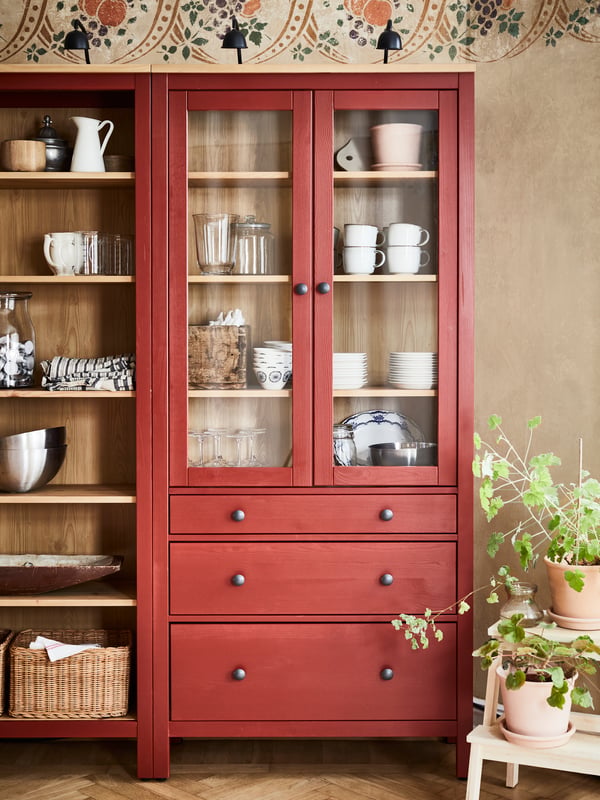 A red HEMNES bookshelf and a red HEMNES glass-door cabinet.