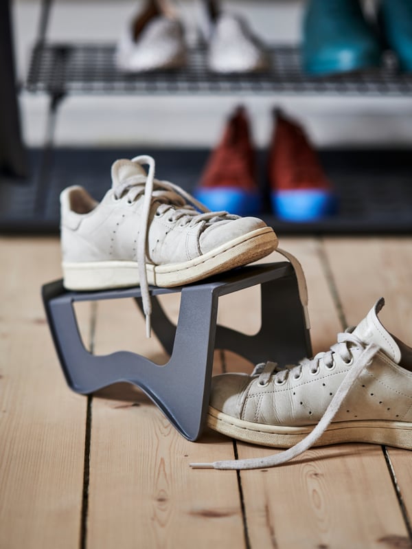 Un zapatero MURVEL plástico con zapatillas en un pasillo.