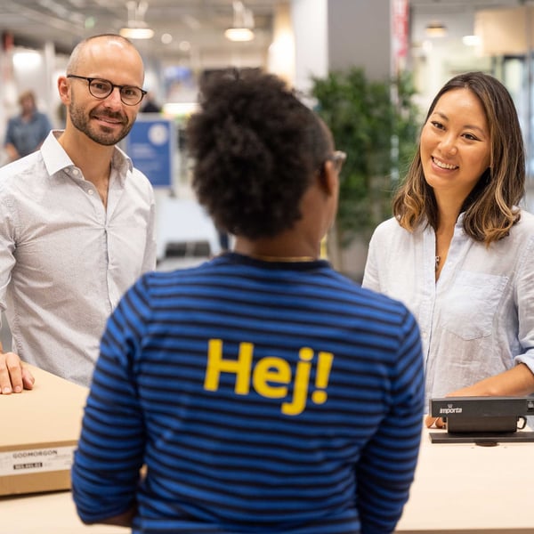 Two customers talking to a co-worker at an IKEA store.