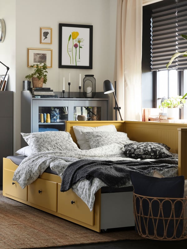 Bright yellow pull-out day bed HEMNES in the living room.