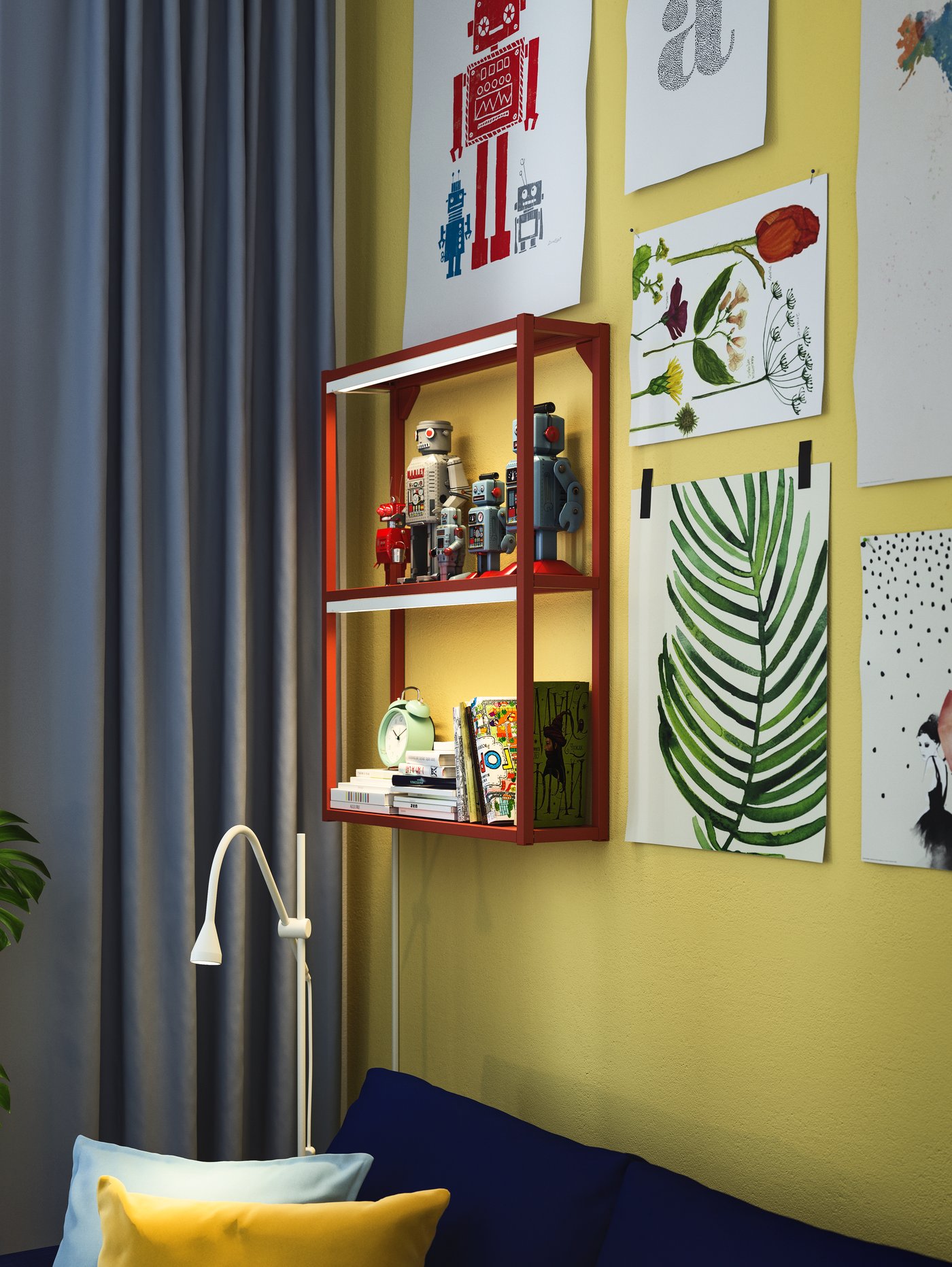 A red ENHET wall frame with shelves on a yellow wall, displaying robot toys, notebooks and a green alarm clock.