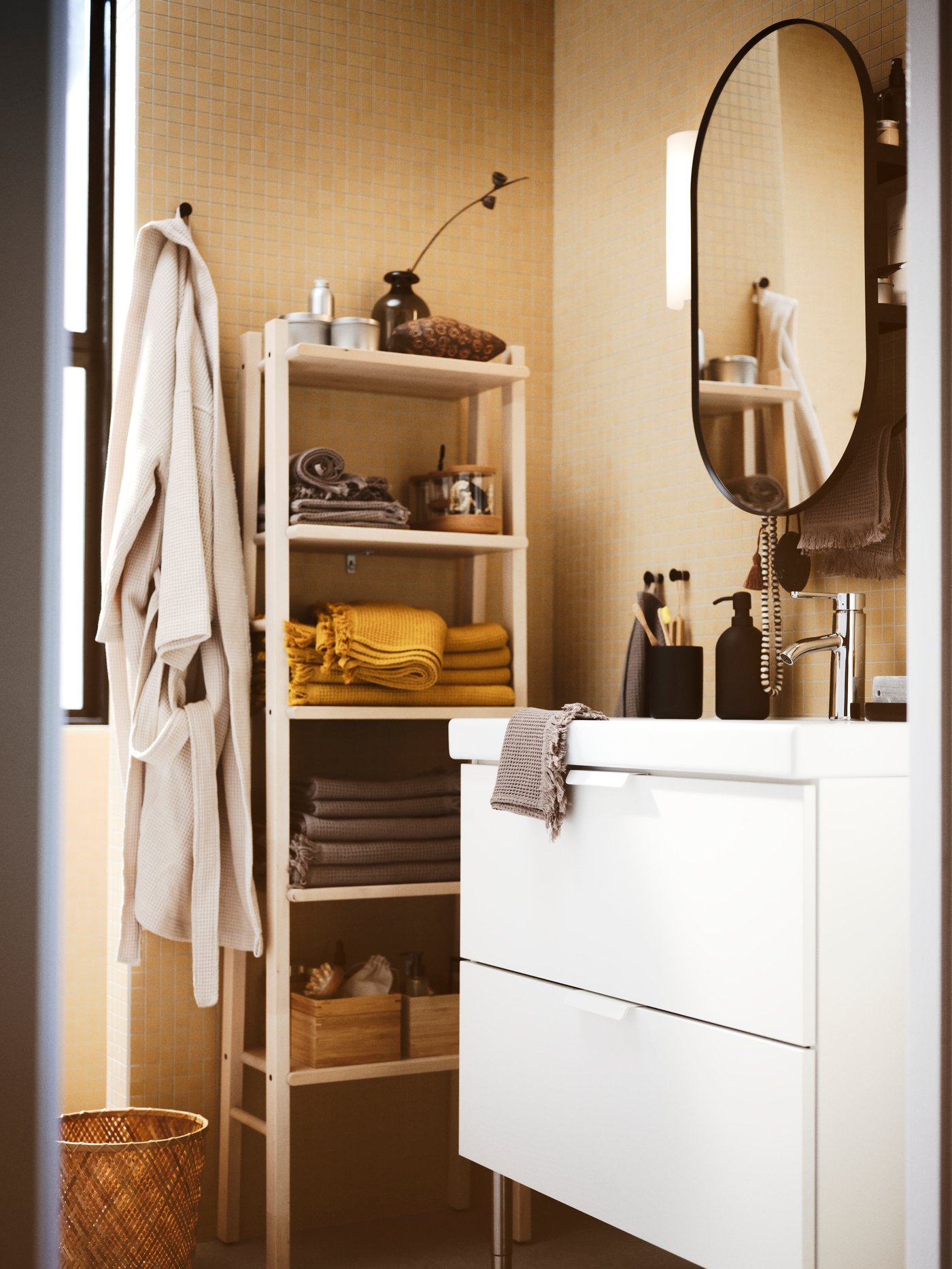 Beige toned bathroom with white GODMORGON vanity. Shelf unit against wall with towels folded. Rovbe hangning from edge