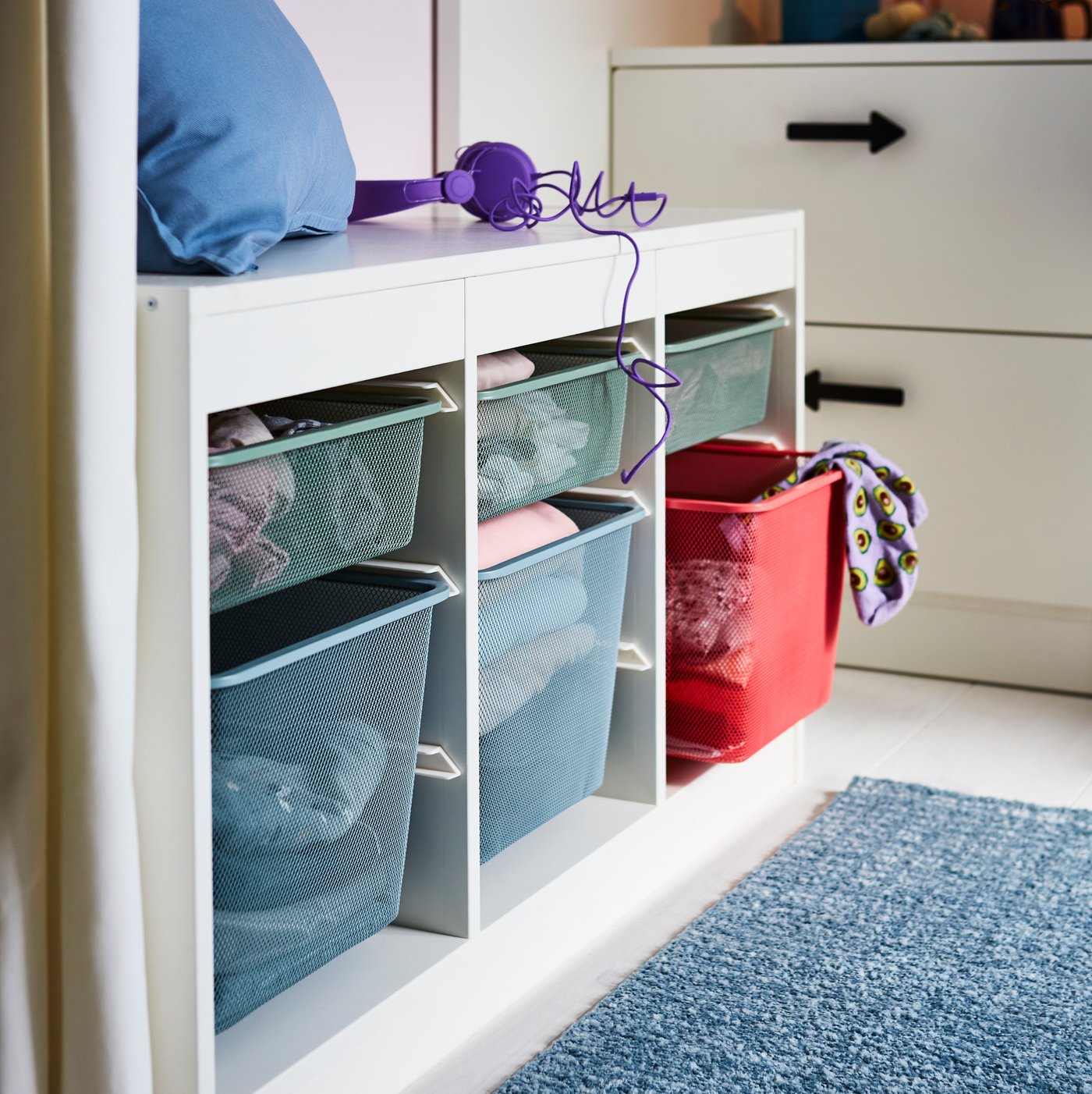 TROFAST frame and storage boxes in children's room with LILLABO toy train on floor next to MINNEN children's bed.