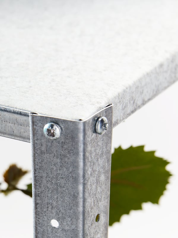 A metal joint on a HYLLIS shelving unit. Part of a larger image showing a corner section of a HYLLIS shelving unit.