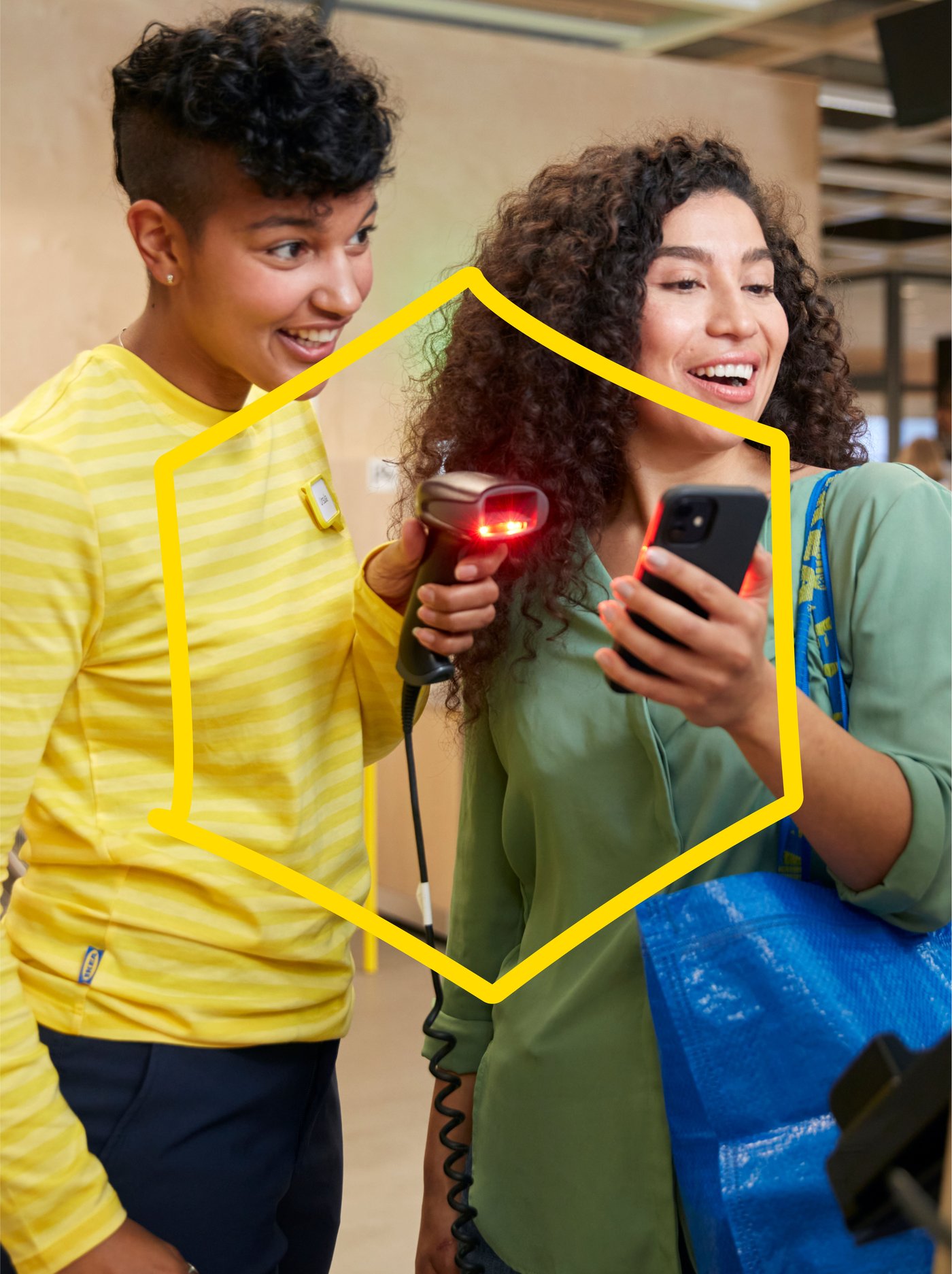 An IKEA employee and a customer scan a product in the store with a yellow diamond overlay across the image.