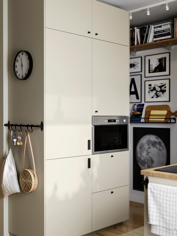 A kitchen has METOD cabinets and an integrated fridge/freezer with beige HAVSTORP fronts and a MATÄLSKARE microwave oven.