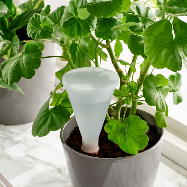 A terracotta/transparent SVÄMSKOG self-watering insert outside