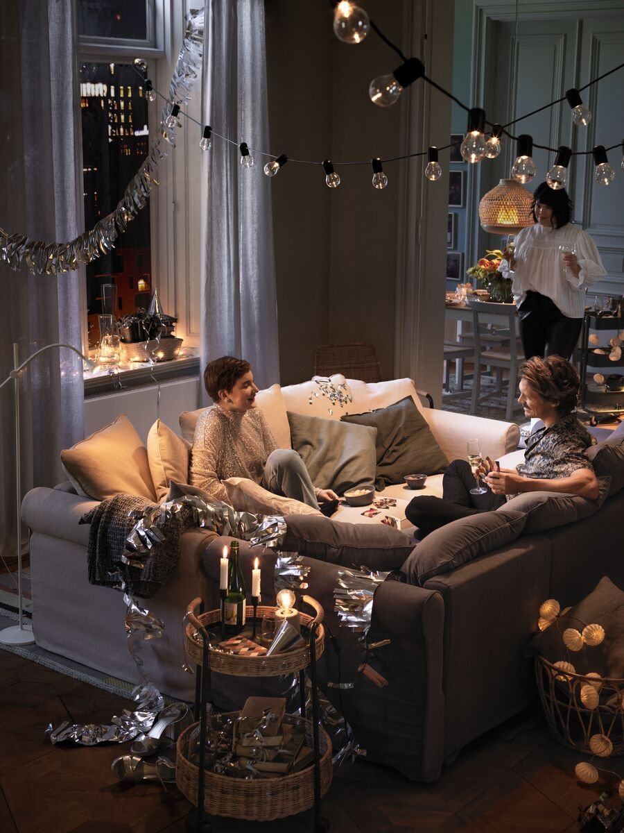 A black/outdoor SVARTRÅ LED lighting chain with 12 lights in the living room
