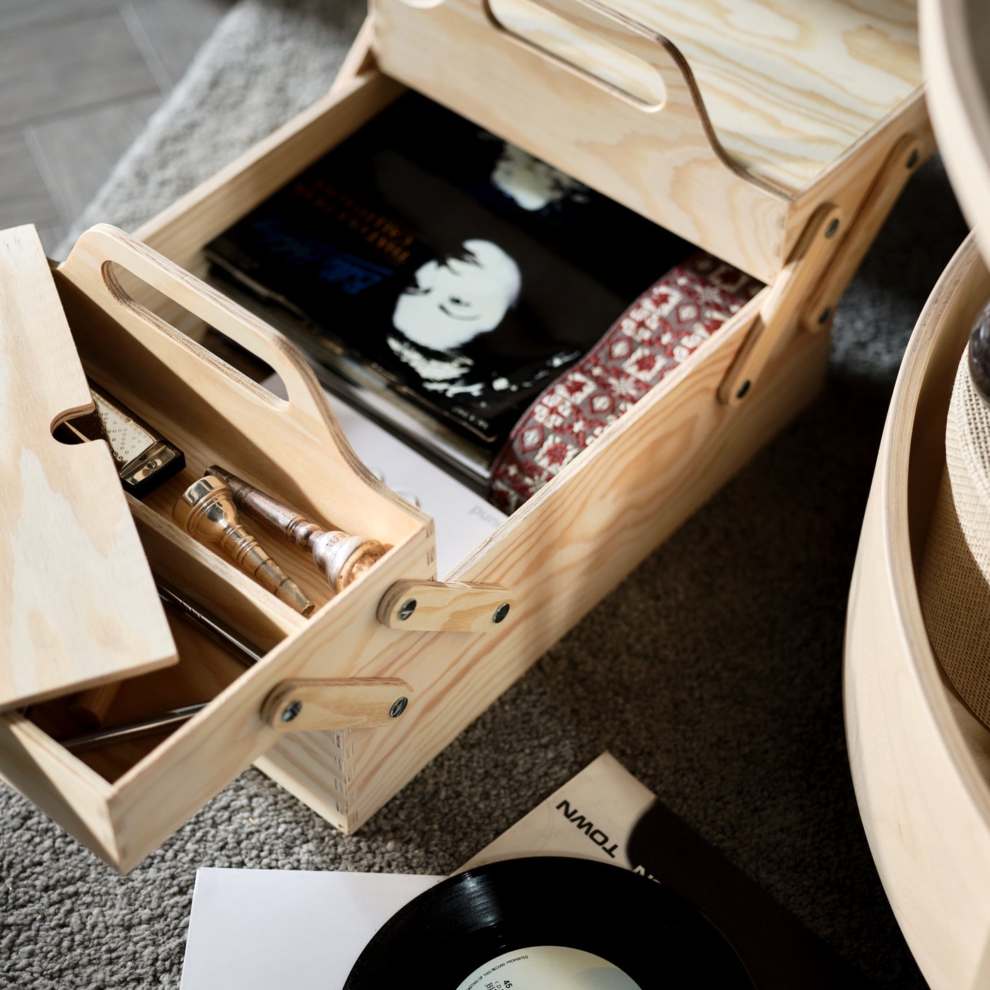 Un article de rangement en bois naturel ouvert avec des CD de musique à l’intérieur.