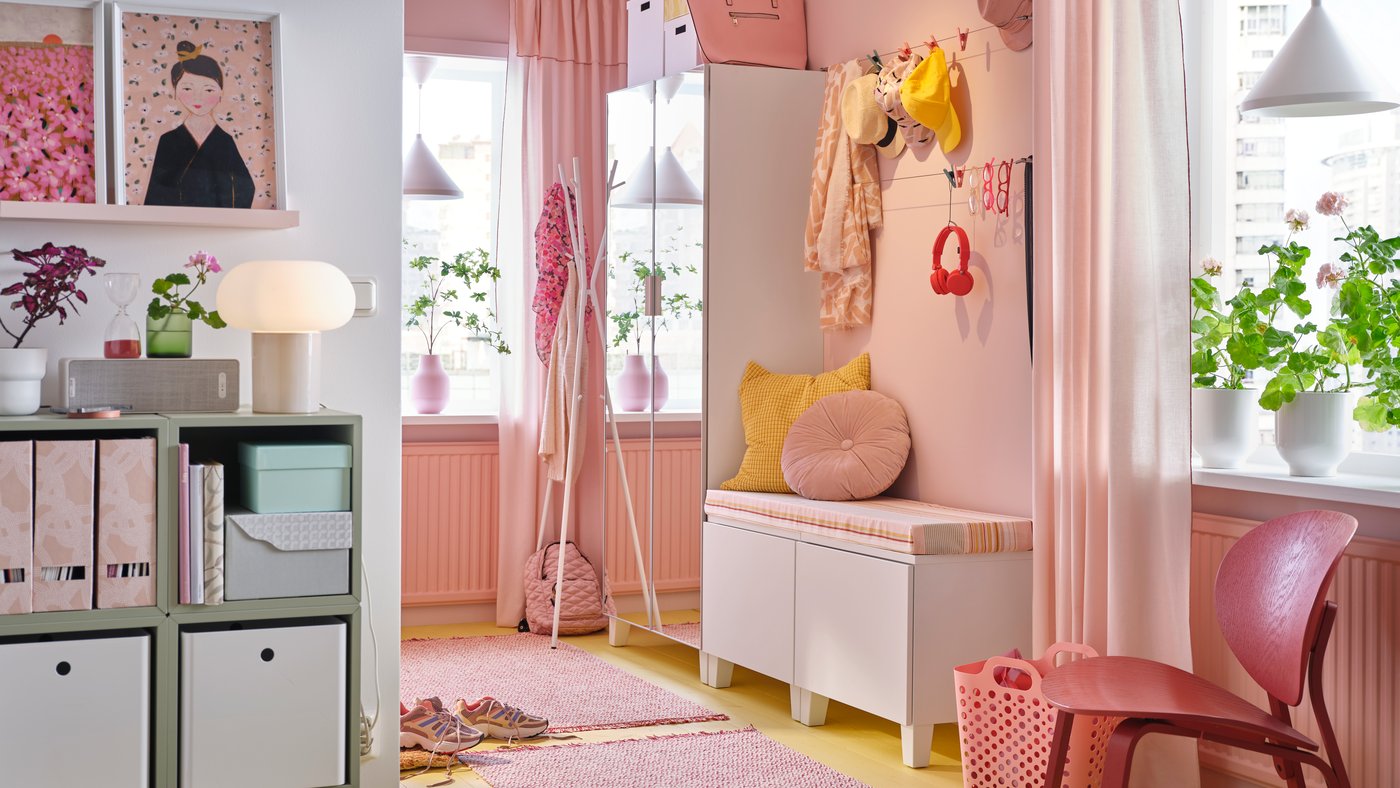 A pink room filled with furnishings and storage in various sizes.