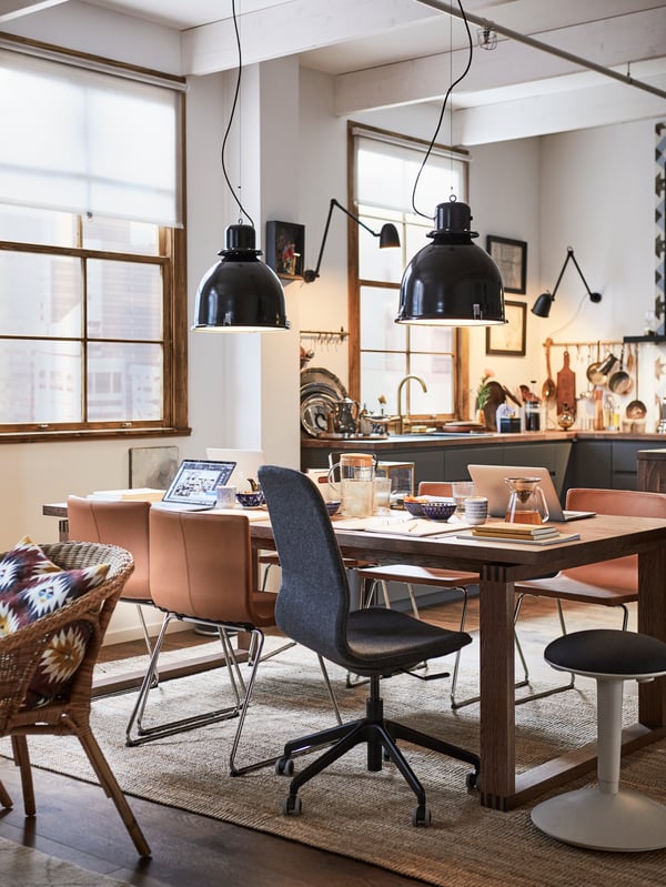 A dining room being used as a working space, with a mix of desk and dining chairs around a MÖRBYLÅNGA dining table.