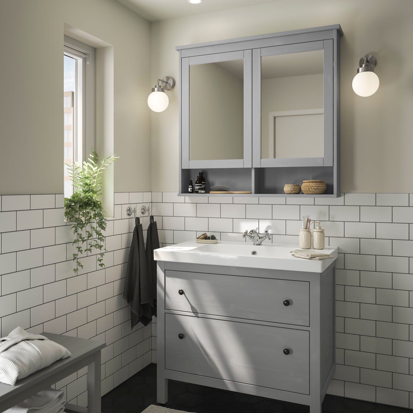 Light bathroom with gray vanity, mirrored cabinet and white tile walls.