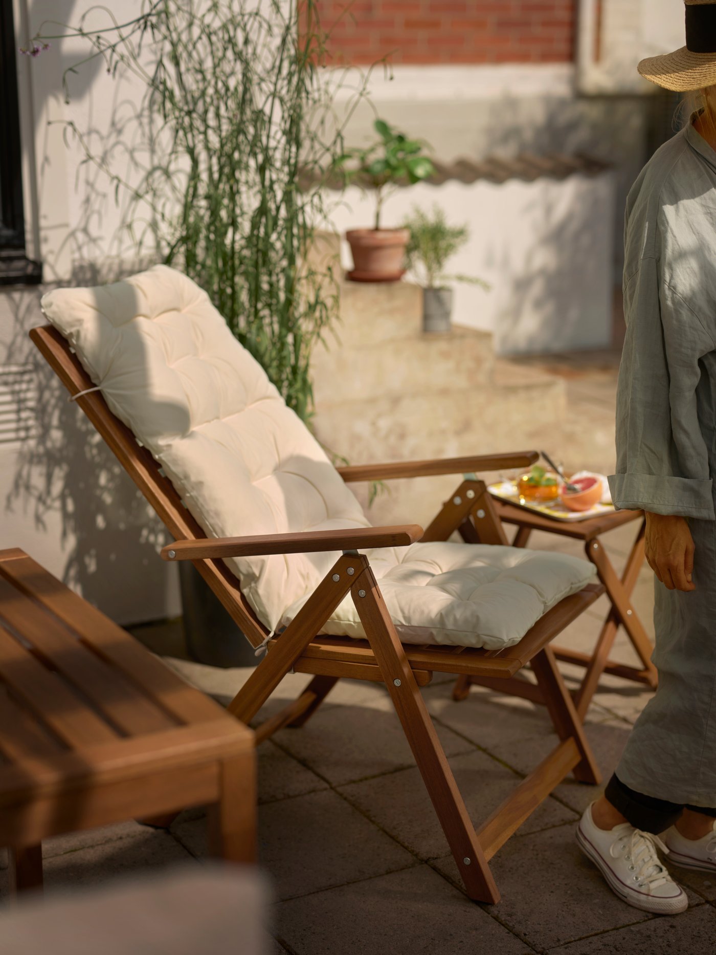 Una silla de terraza reclinable NÄMMARÖ en un patio soleado.