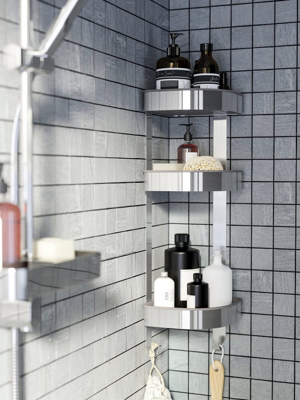 Organizador de metal de shampoos BROGRUND con productos en el, pegado a la pared de la ducha de un baño.