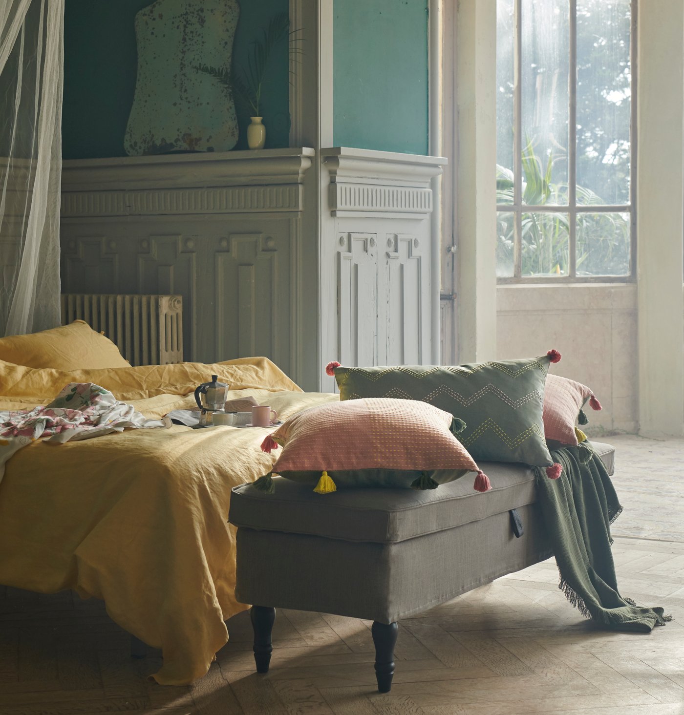 Ein Schlafzimmer mit einer Ablage vor dem Bett auf der sich Kissen befinden.