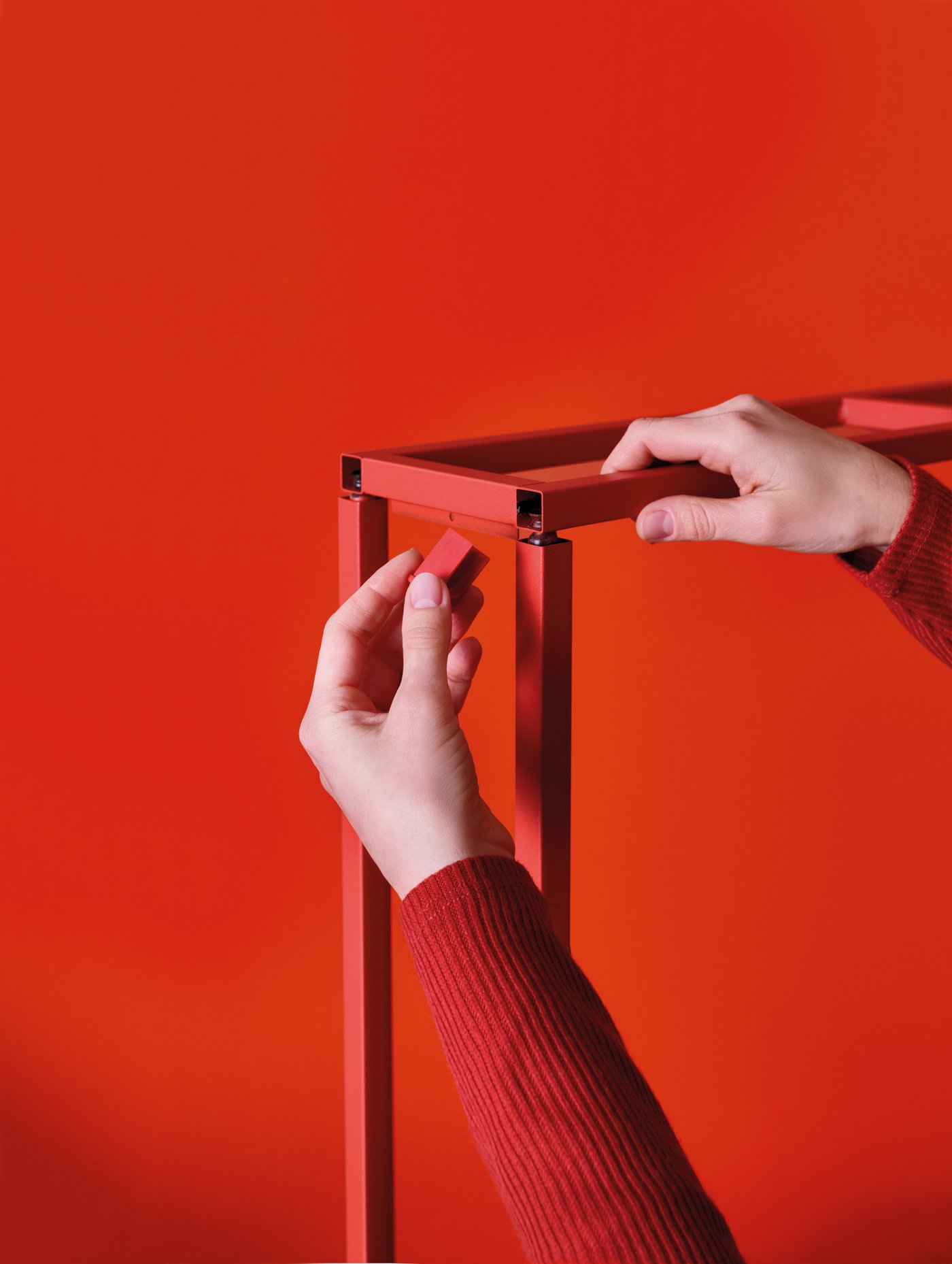 A red-orange ENHET wall frame with shelves in the NA