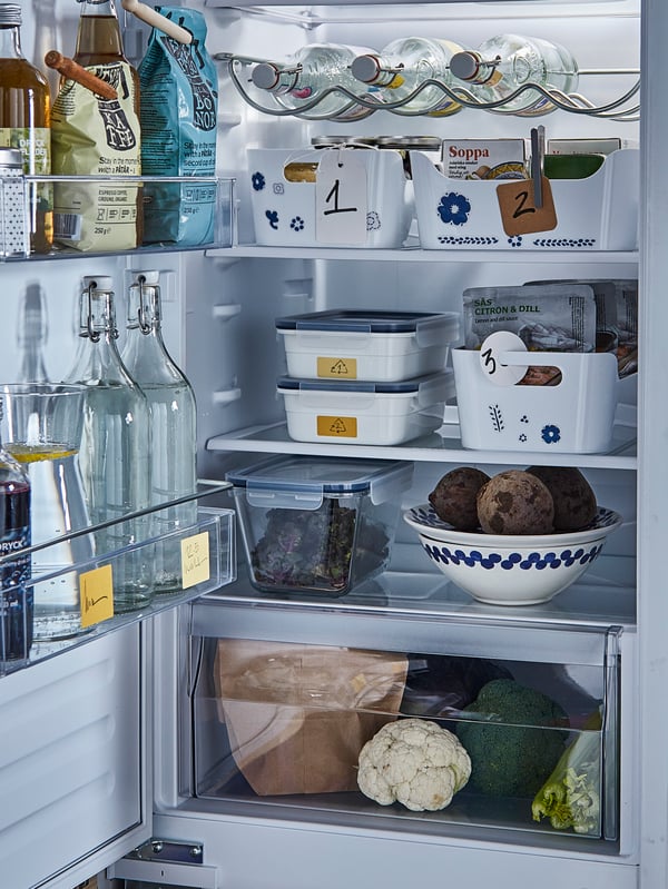 An open fridge with neatly organised food and drink with labels on to show what to consume first.