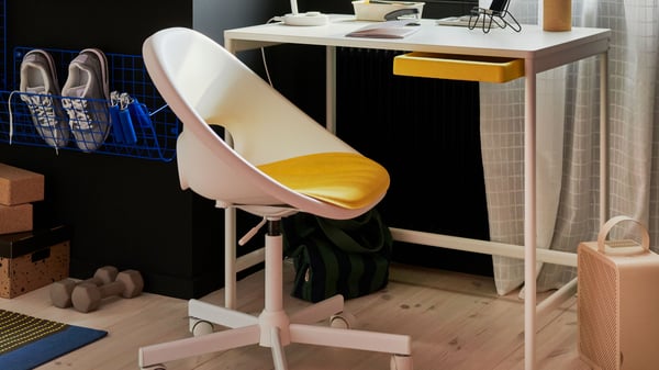 Une vue en gros plan montre une chaise pivotante blanche LOBERGET placée devant un bureau blanc dans un bureau.