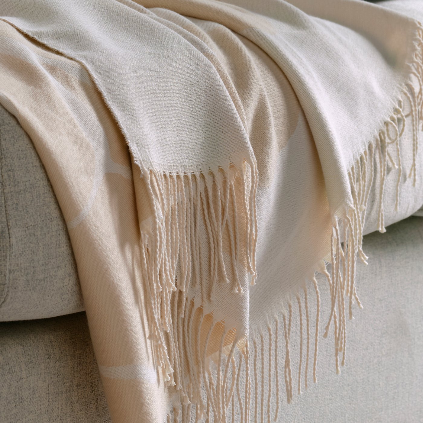 PERSIKOTRÄD throw 150x200 off-white/grey-beige AP on a sofa.