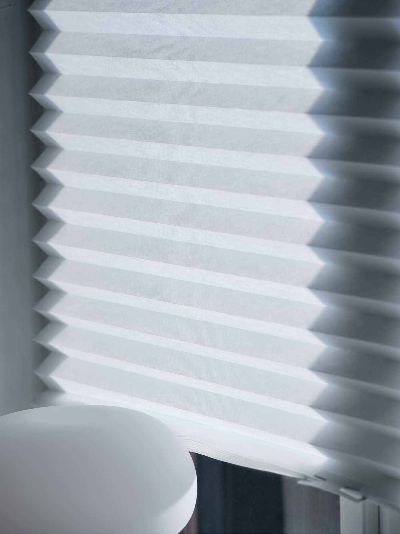 A beige/opal white glass DEJSA table lamp in the bedroom