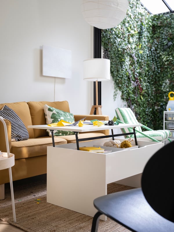 A white ÖSTAVALL adjustable coffee table in the living room