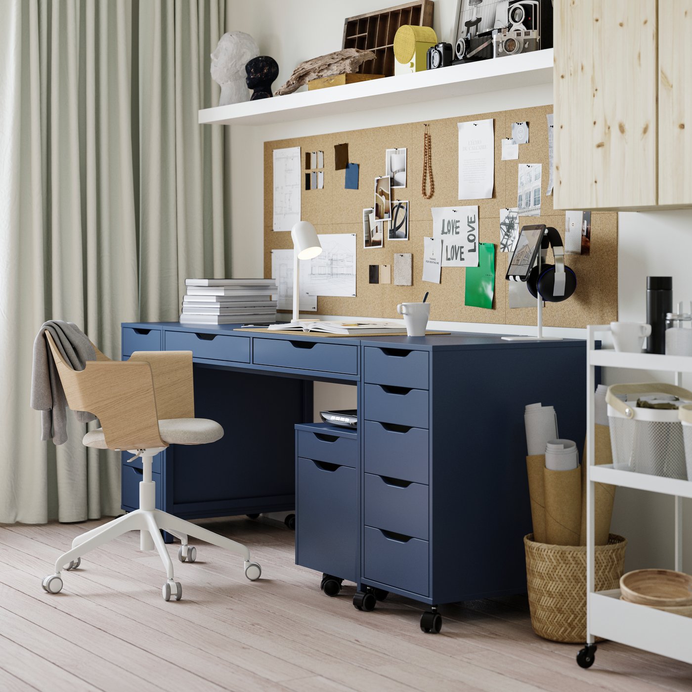 A black-blue ALEX desk in a student room, with on each side a drawer unit. Under the desk sits a smaller drawer unit as too.
