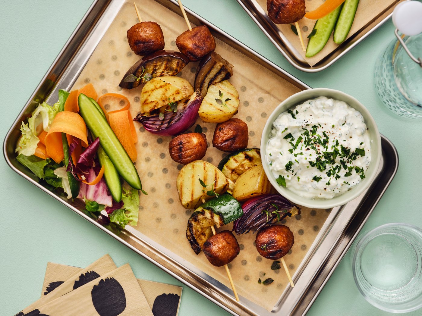 Albóndigas en brochetas con verduras y queso feta.