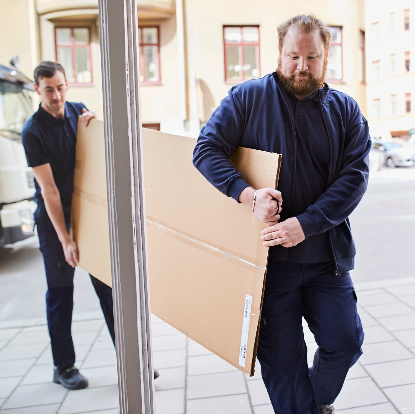 2 men carrying flatpack box