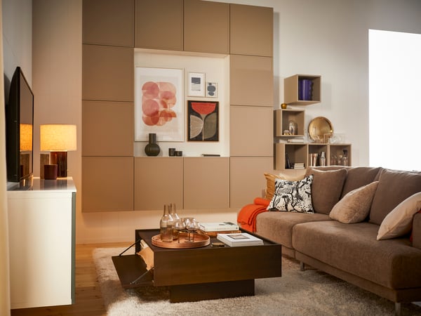 Des meubles de rangement BESTÅ beige contre le mur du salon.