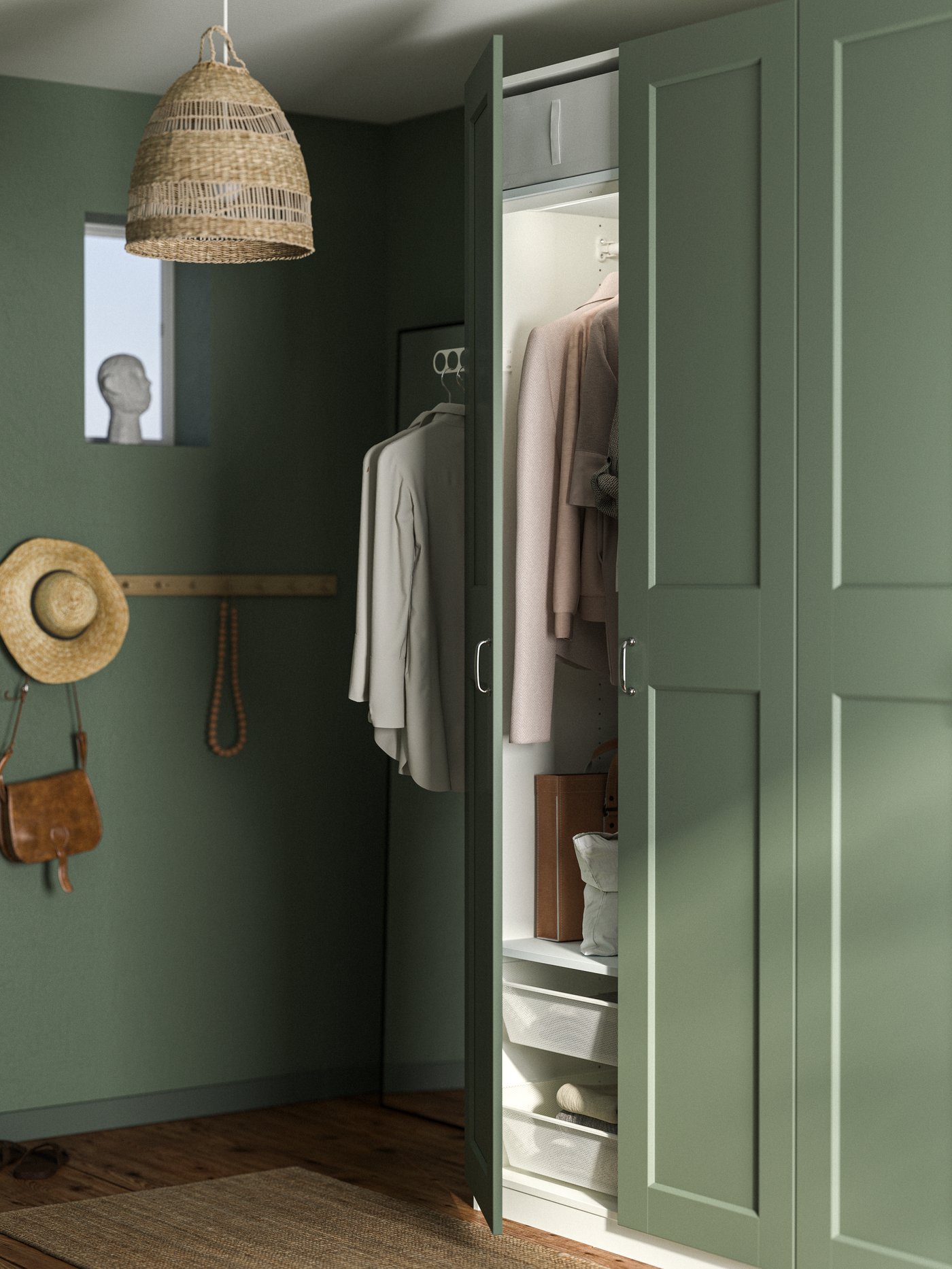 Close-up of PAX wardrobe with grey-green GRIMO doors in a room with walls in the same colour. One door open on the wardrobe.