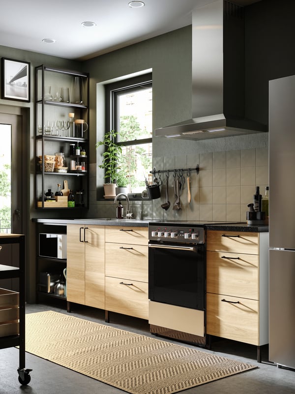 Una cocina moderna con paredes y suelos grises, una cocina ENHET en antracita y frentes en efecto roble y estantes de pared negros.