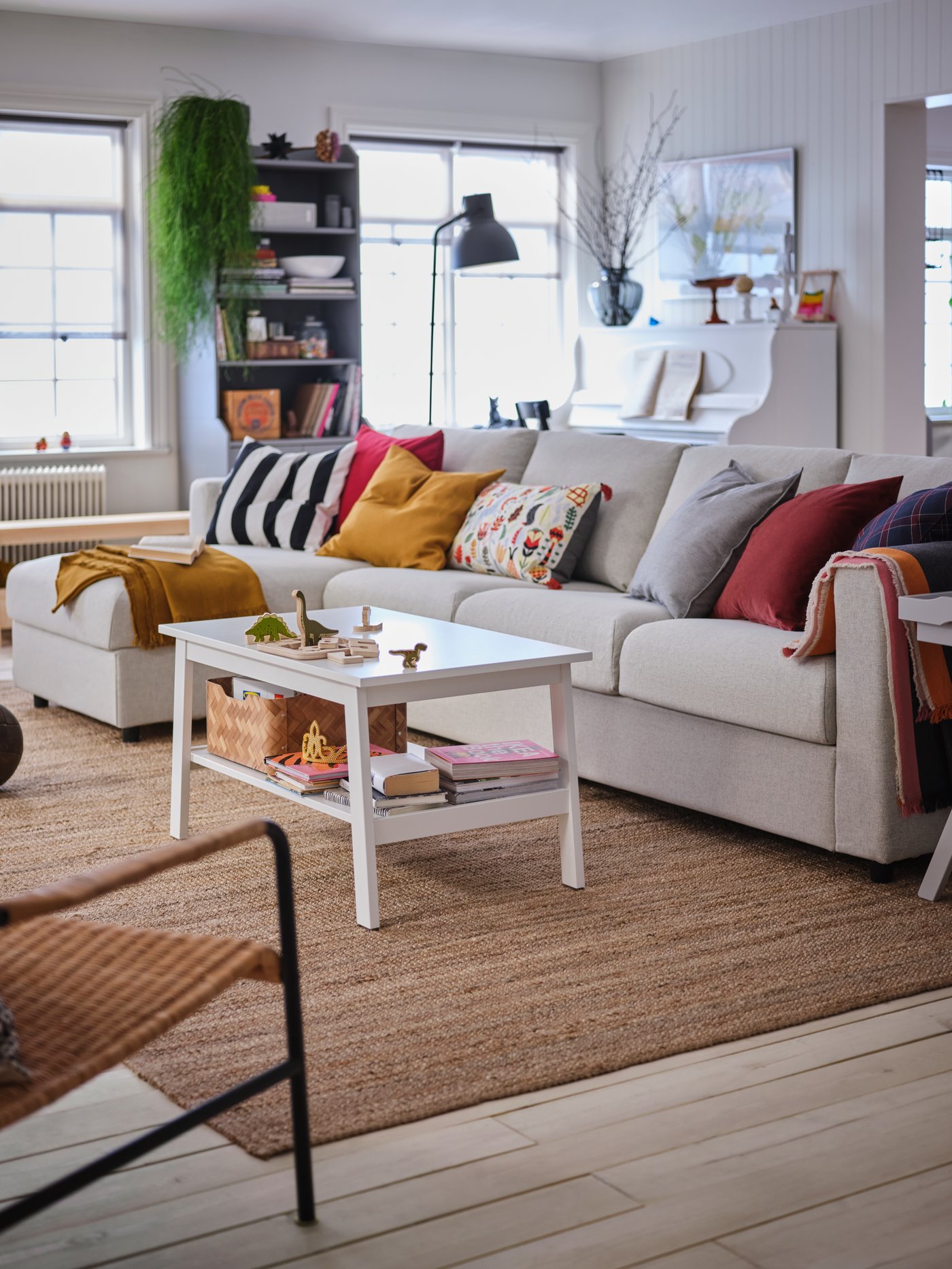 A light VIMLE sofa with colourful cushions and a LOHALS rug in the living room.