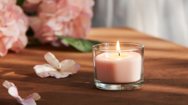 A Pink flowers pale pink LOTSFÅGEL scented candle in glass in the NA