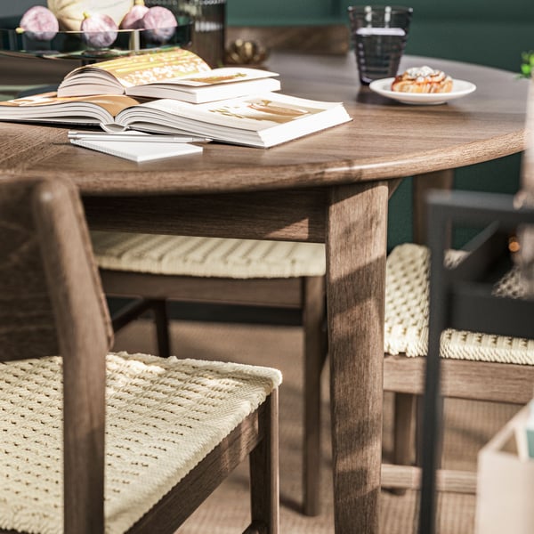 Una mesa de comedor redonda SKANSNÄS café oscuro con cuatro sillas SKANSNÄS.