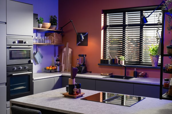 Een moderne keuken met METOD kasten en een werkblad, gecombineerd met open planken en lampen, creëert een warme en functionele ruimte met blauwe en terracotta accenten.