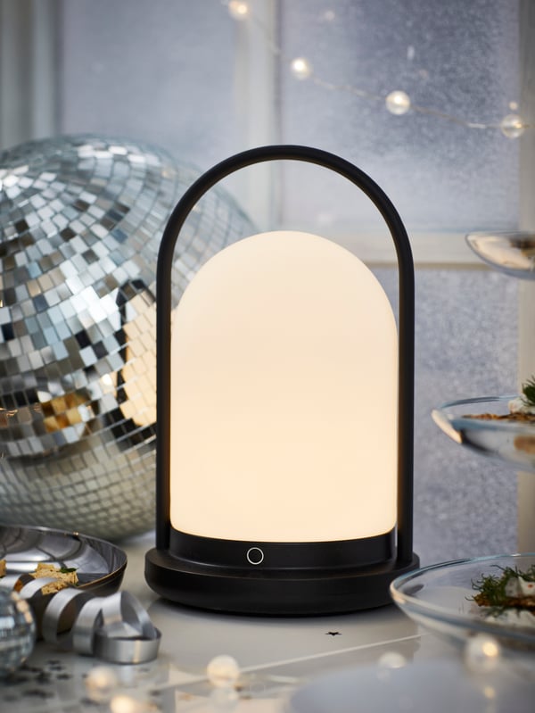 A battery-operated outdoor/dimmable black FRÖJDA LED lantern