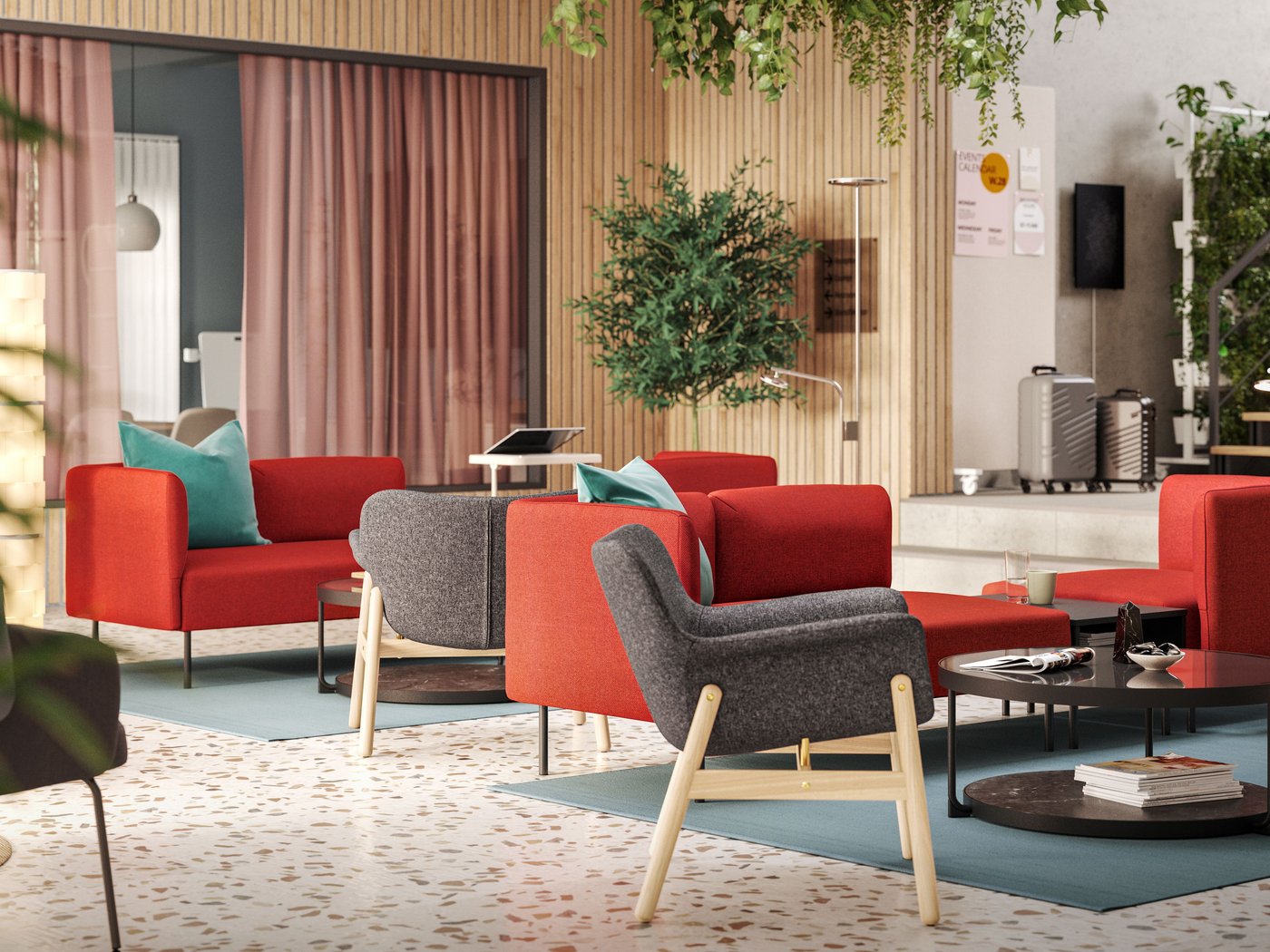 Grupisana rešenja za sedenje s tamnosivim VEDBO foteljama i crvenim modularnim sofama nalaze se na sredini osvetljenog, modernog hotelskog salona.