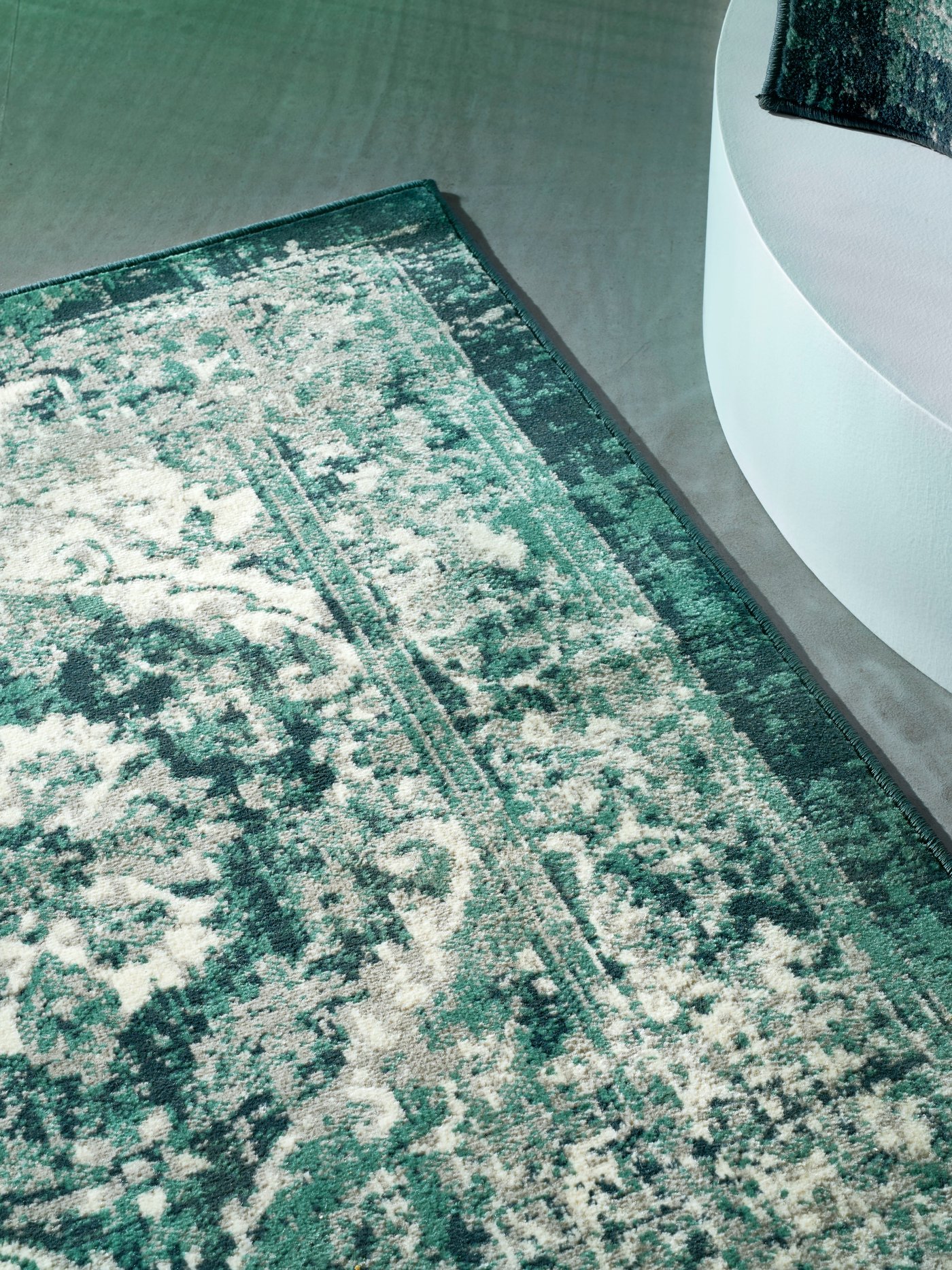 A softly crumpled TÅNUM multicolour rug placed on a grey-tiled floor.